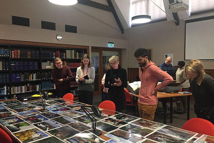 Staff and students looking at display of photographs